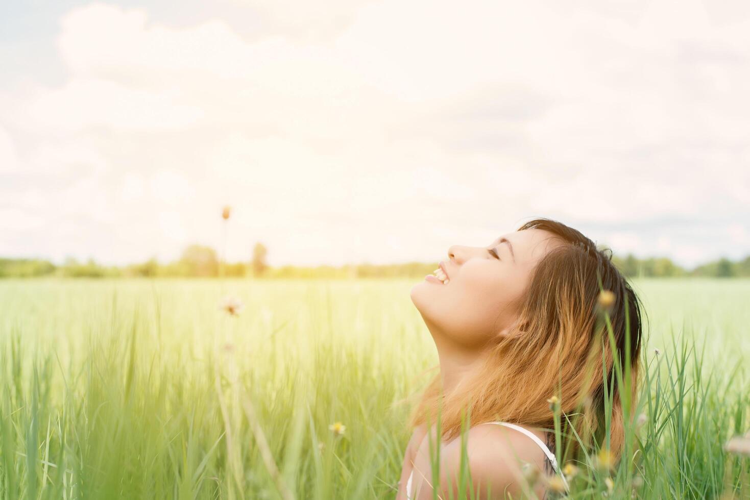 young beautiful woman sitting on grassland enjoy nature and fresh air happy. photo