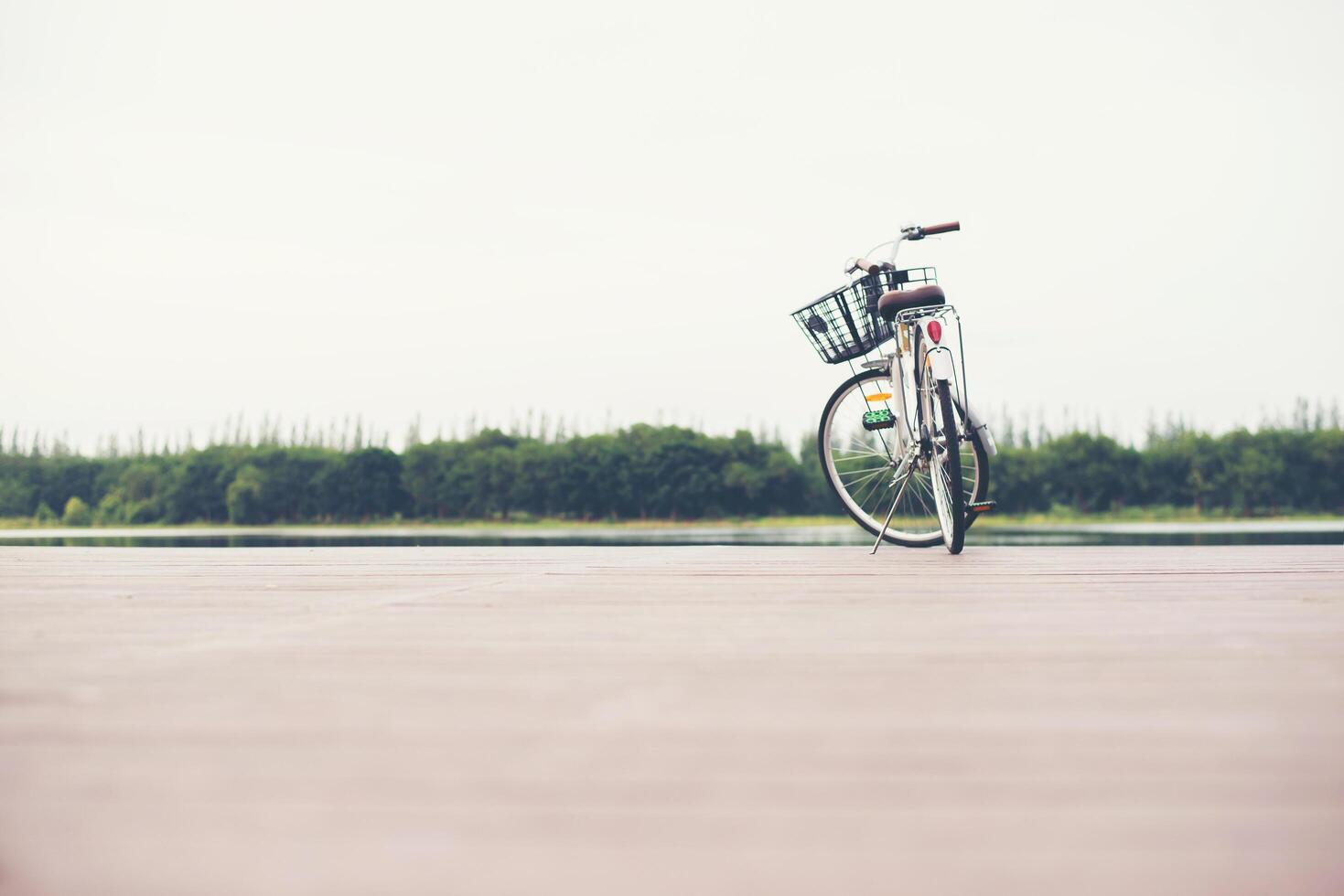 tono vintage de bicicleta con cesta en muelle vacío, día de verano. foto