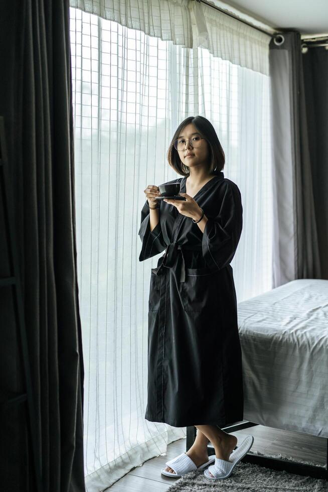Women wearing black robes, handing coffee in the bedroom. photo