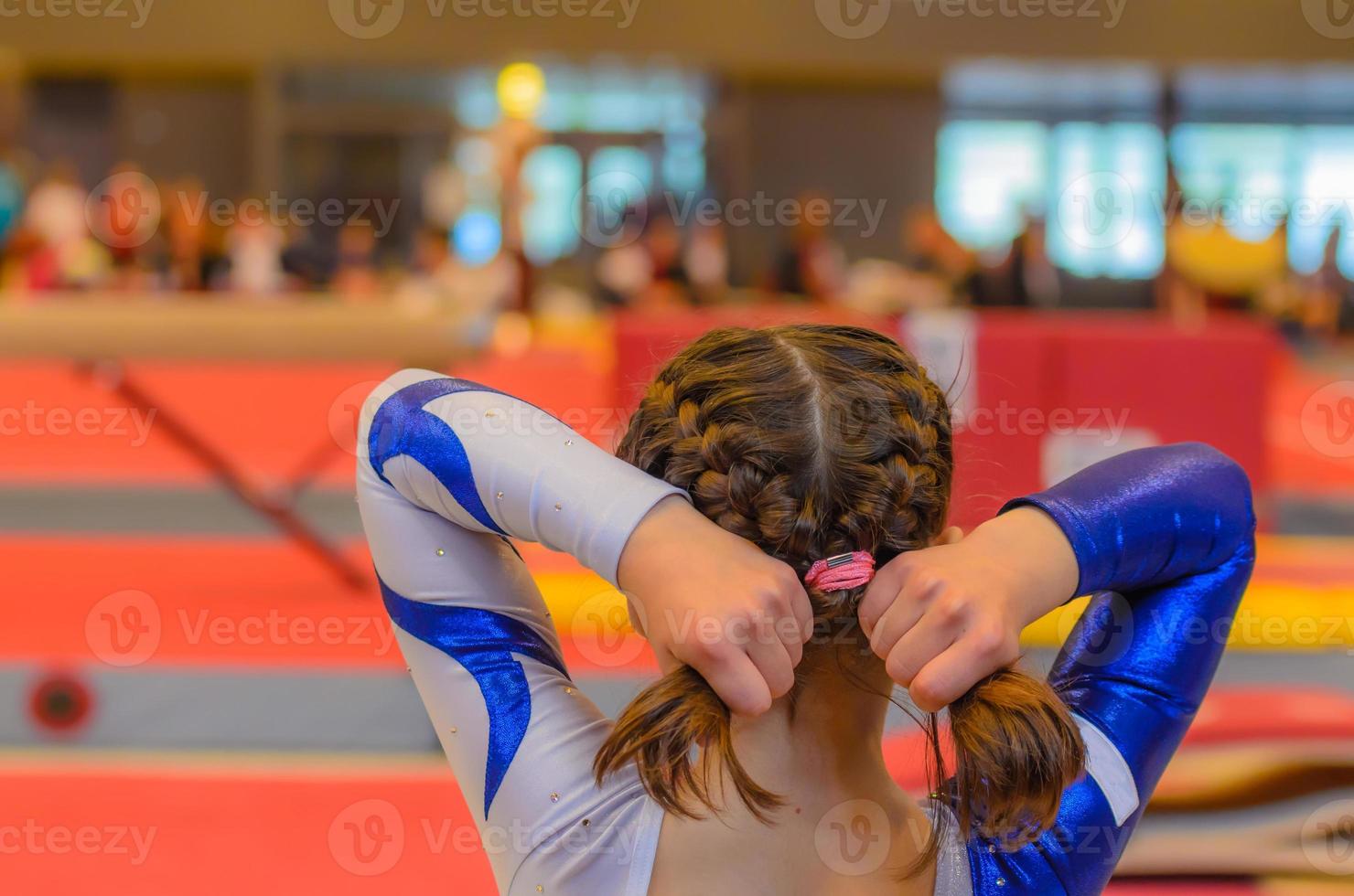 joven gimnasta arreglando el cabello antes de la aparición foto