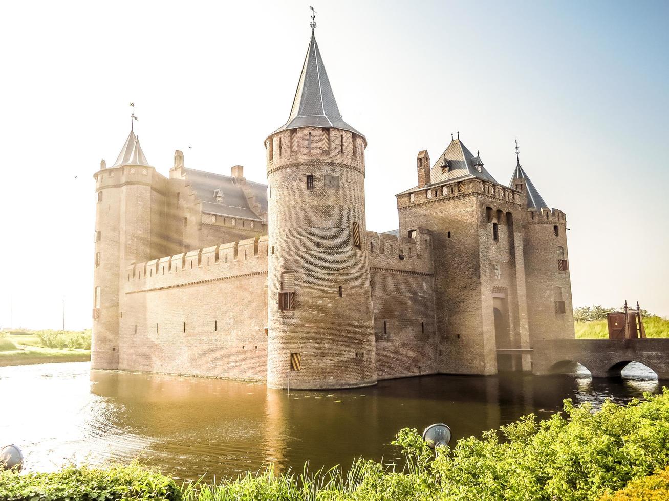 Medieval fortress with moat lit by sunshine photo
