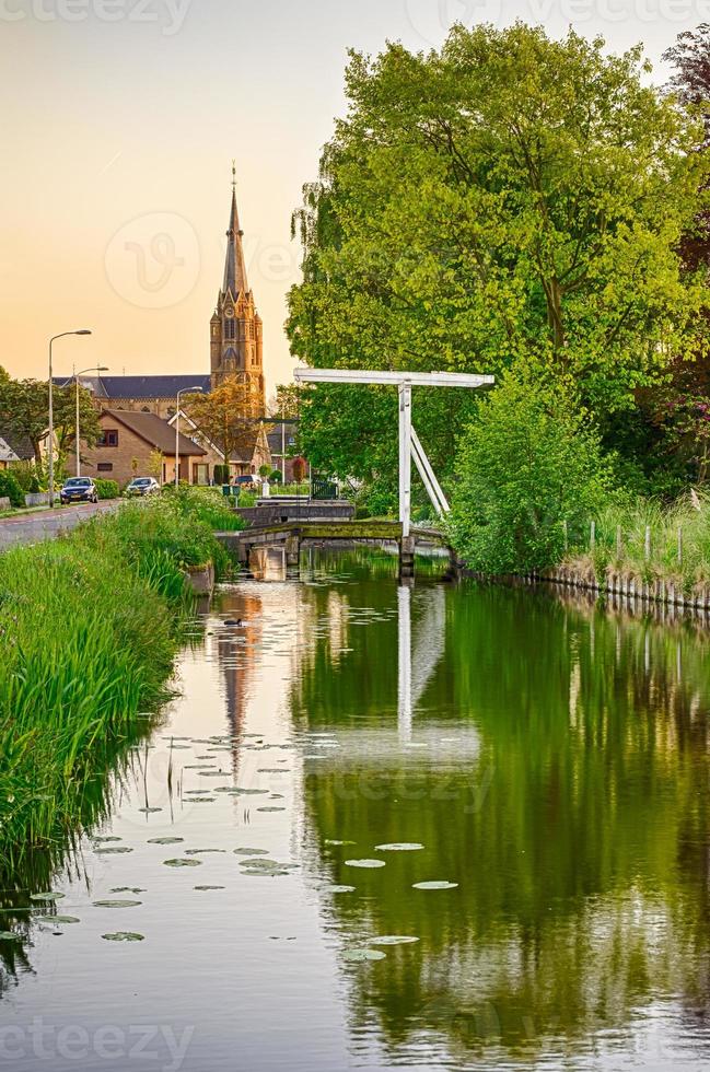 Old Dutch bridge, canal and church photo