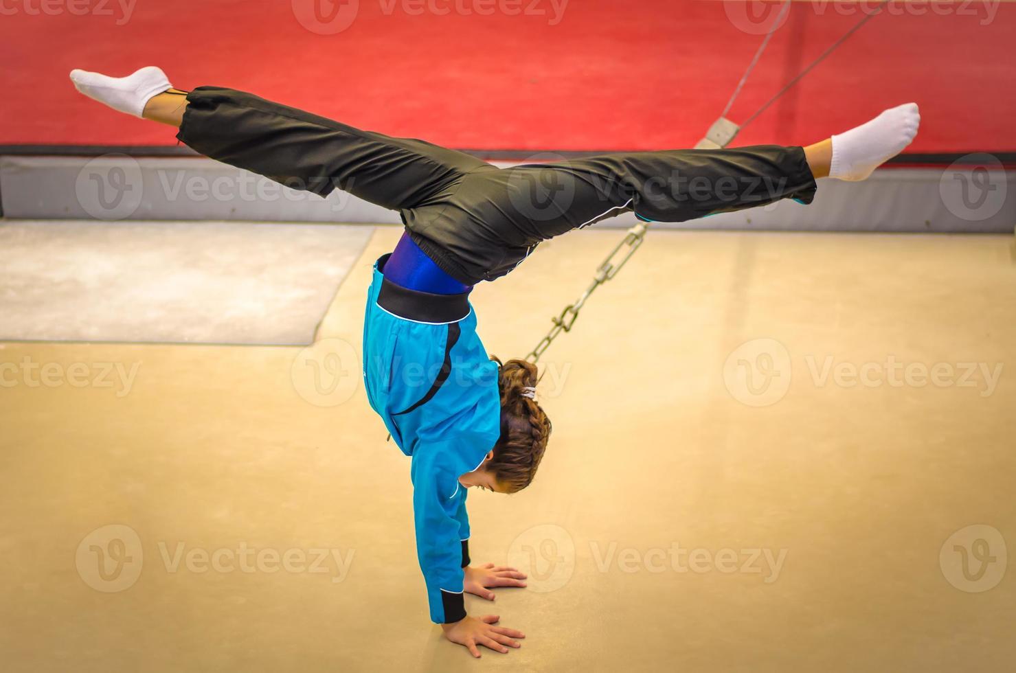 joven gimnasta practicando parada de manos foto