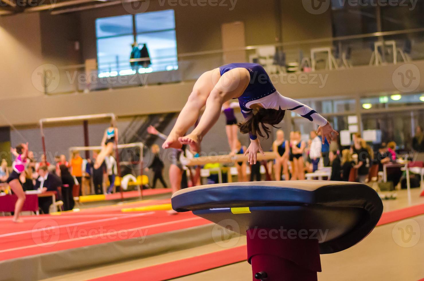 Young gymnast girl performing jump photo