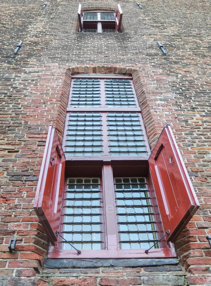 Red shutters on old castle window photo