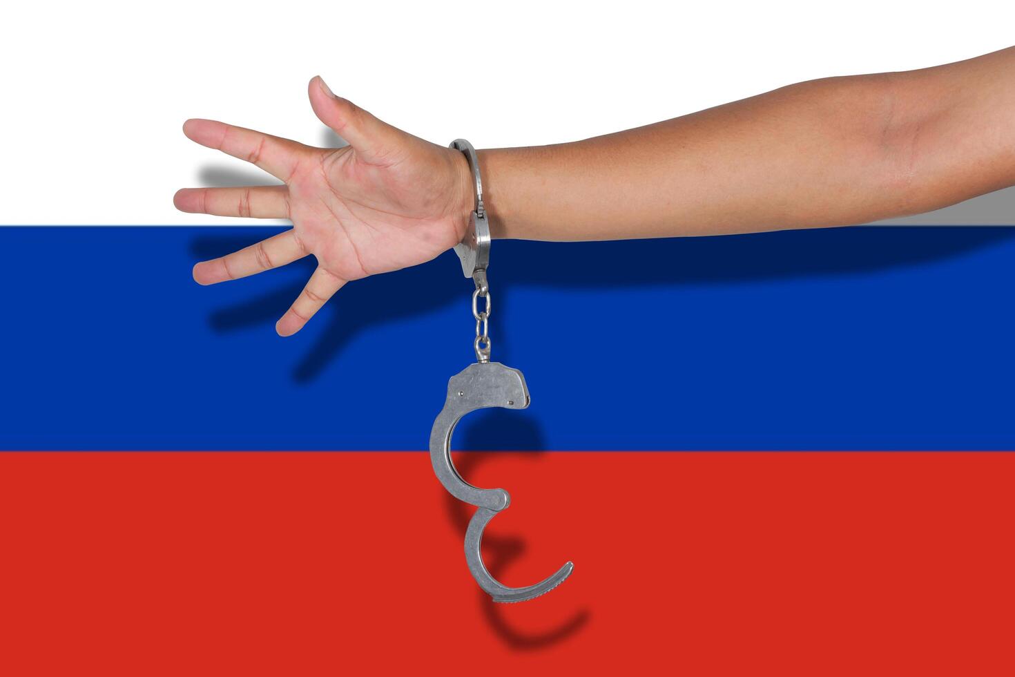 handcuffs with hand on Russia flag photo