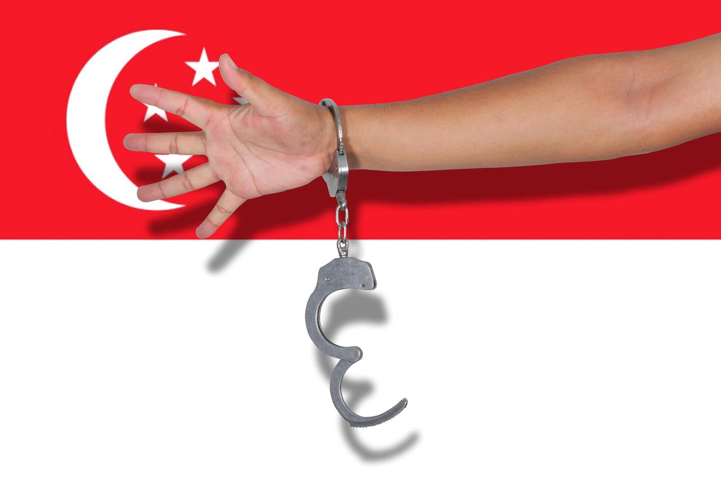 handcuffs with hand on Singapore flag photo