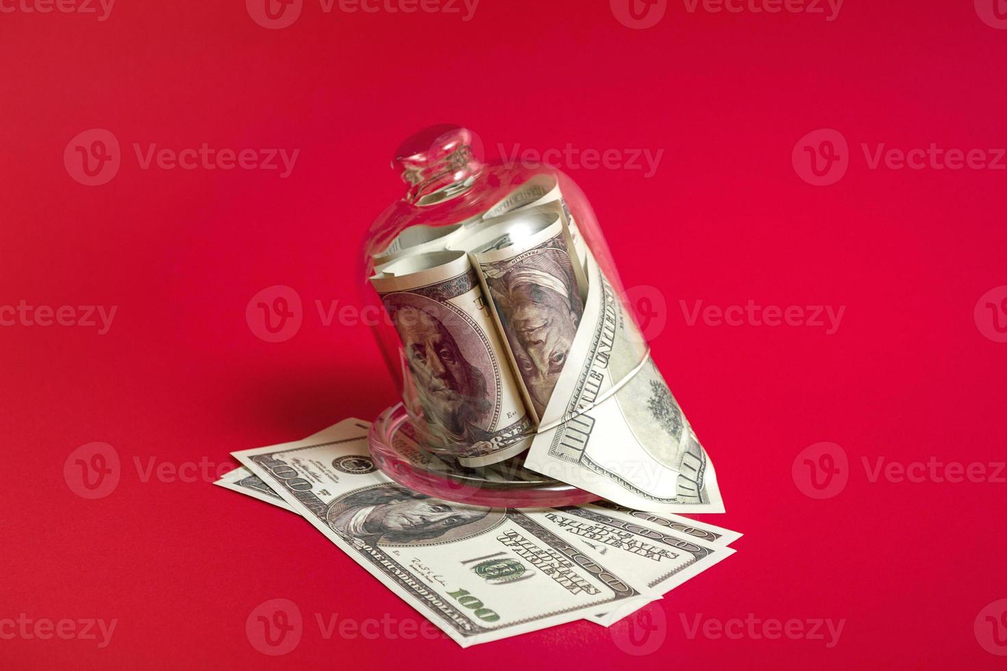 concepto de arrendamiento. carrito de compras y hucha con billetes de dólar sobre fondo rojo, primer plano. foto