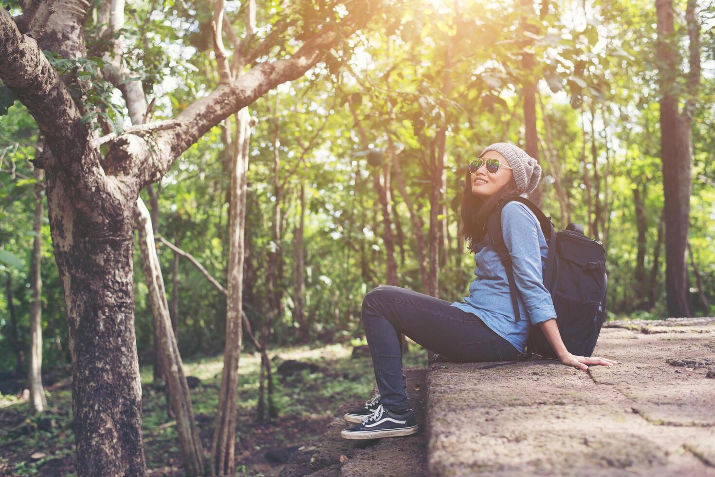 Young attractive woman resting with backpack while going to ancient phanom rung temple in thailand. photo