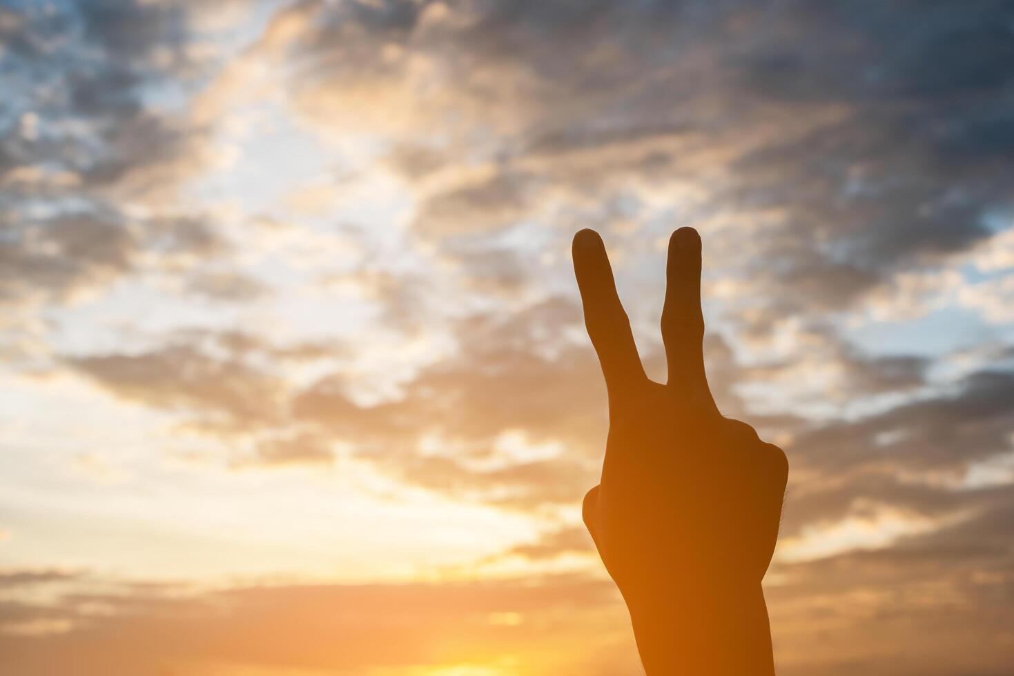 Silhouette of hand shape with sky sunset background. photo