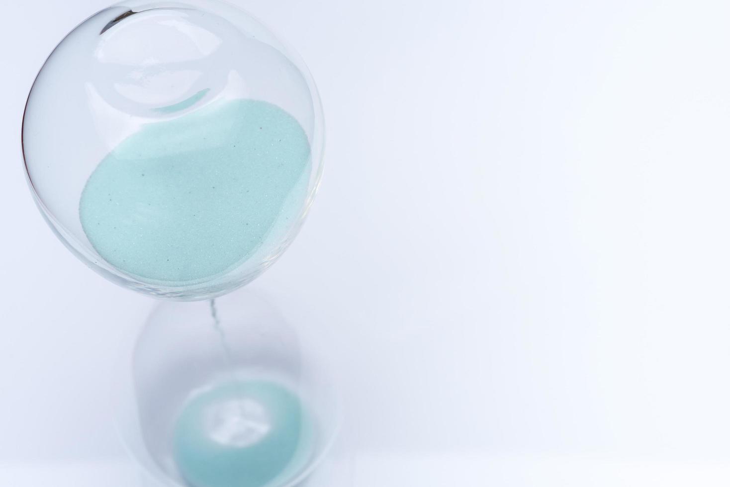 Hourglass on white background. Sand falls inside the flask. photo