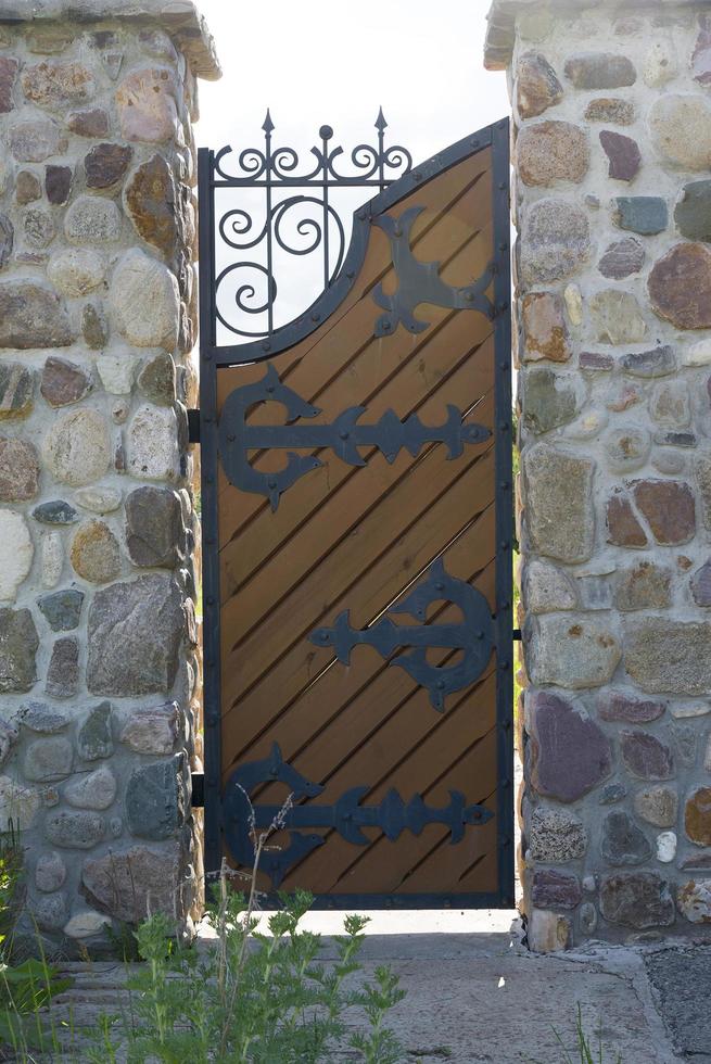 Classical design black wrought iron gates in private yard. photo