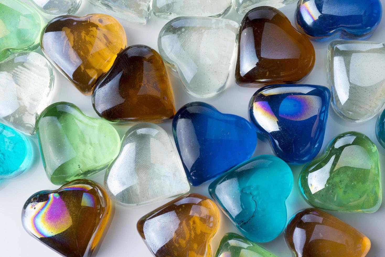 Many glass hearts of different colors. photo