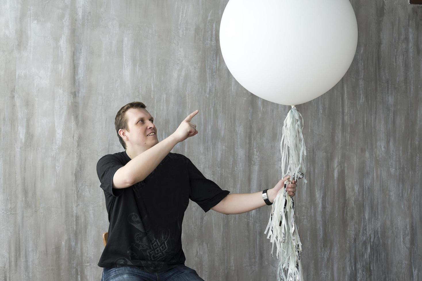 A man holding an inflatable ball on a gray background. photo