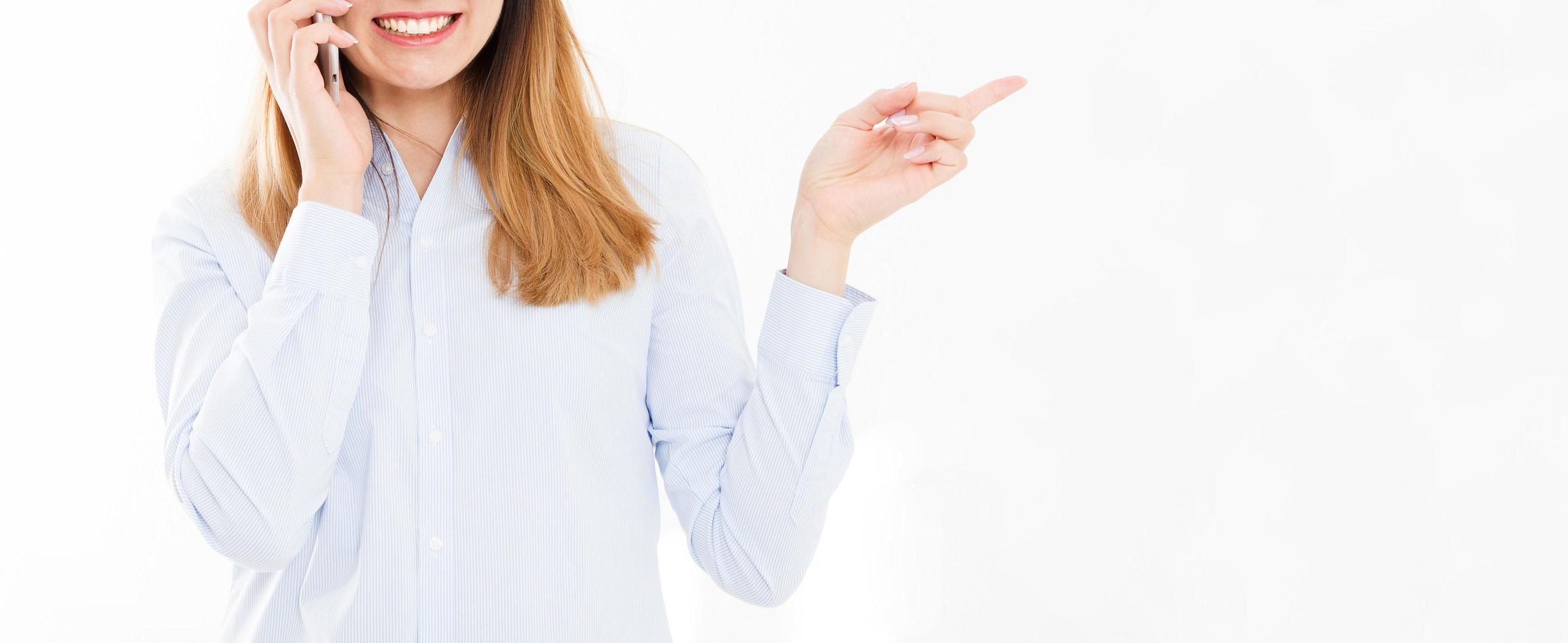 Isolated portrait of business girl with smartphone. Woman tolking on phone and points with his hand. Confident young manager. Copy space photo