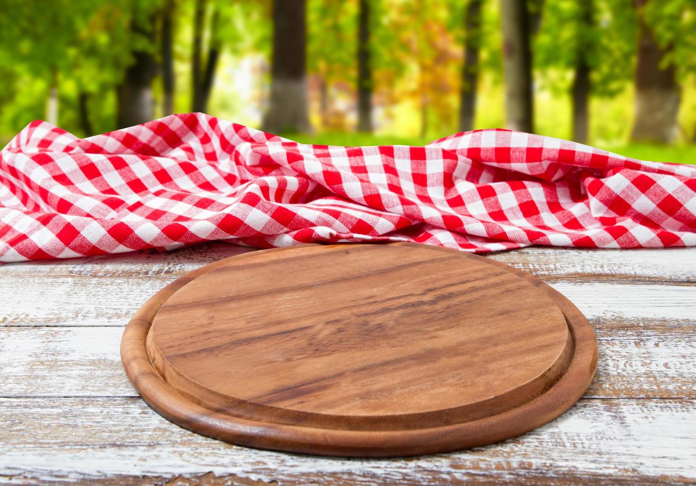 pizza desk checkered tablecloth on a wooden table on blurred forest background photo
