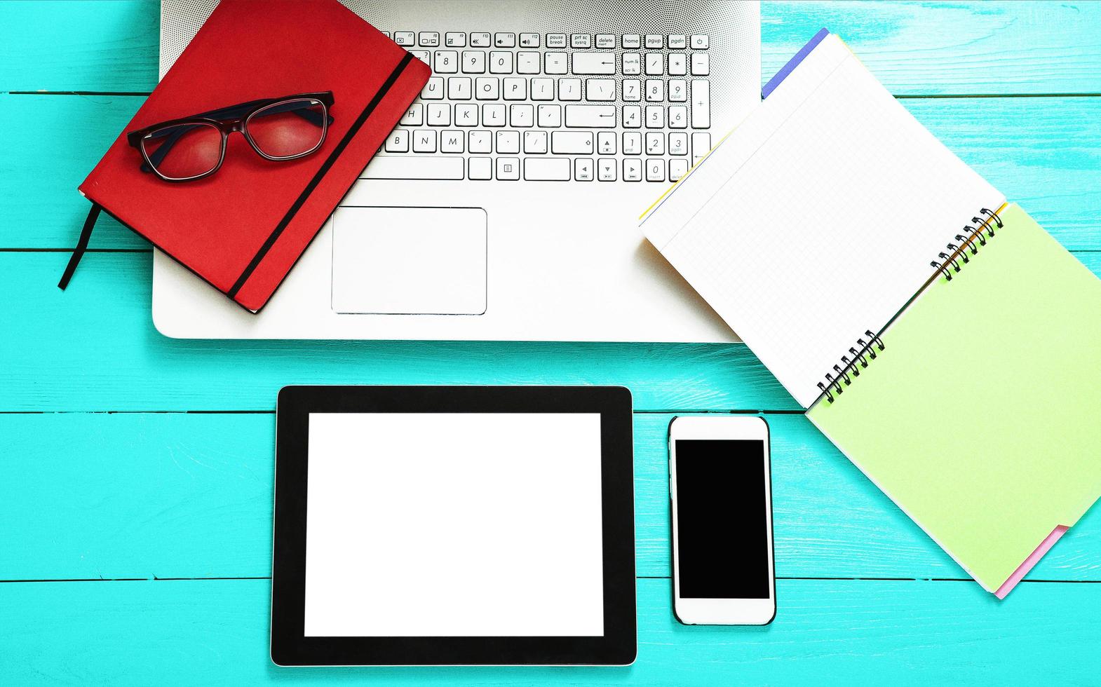 Electronic devices with copy space and keyboard on blue wooden background. Working accessories. Top view photo