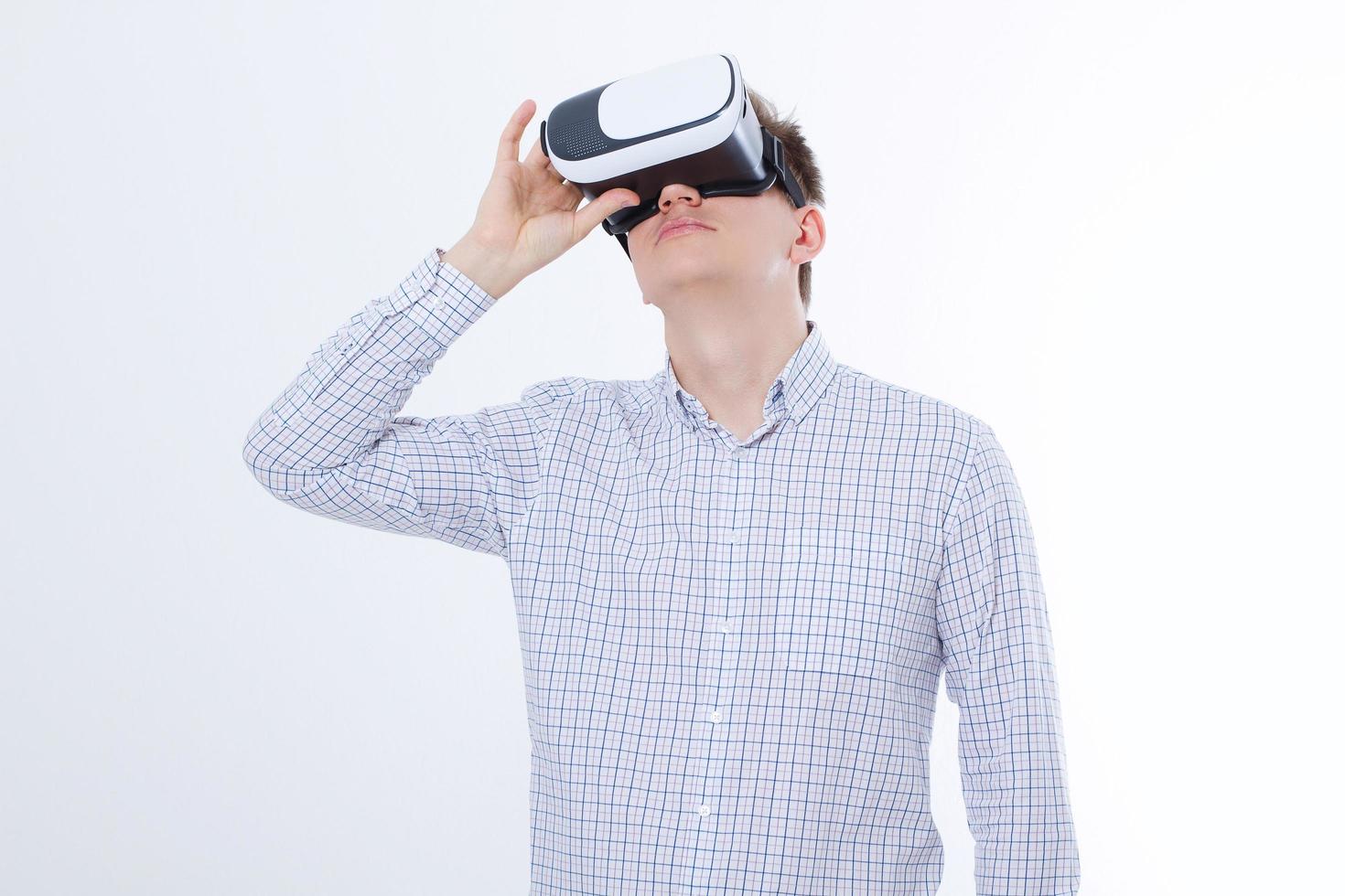 Young business man in vr glasses, goggles watching virtual reality isolated on white background. Copy space and mock up photo