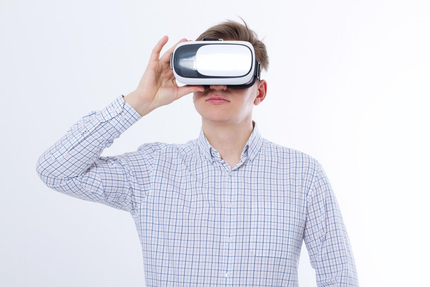 Young business man in vr glasses, goggles watching virtual reality isolated on white background. Copy space and mock up photo