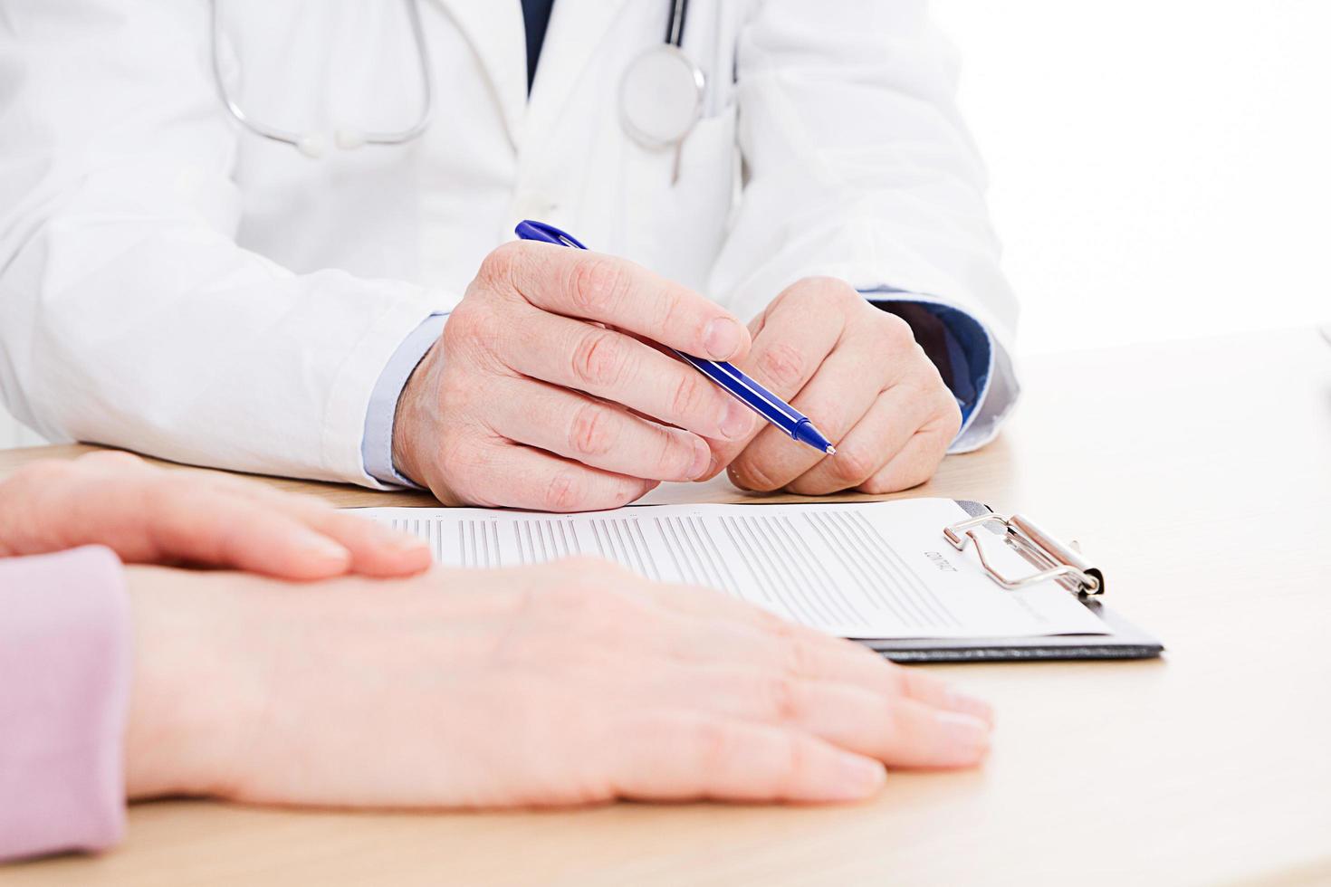 Doctor and patient are discussing something, just hands at the table, medical insurance. photo