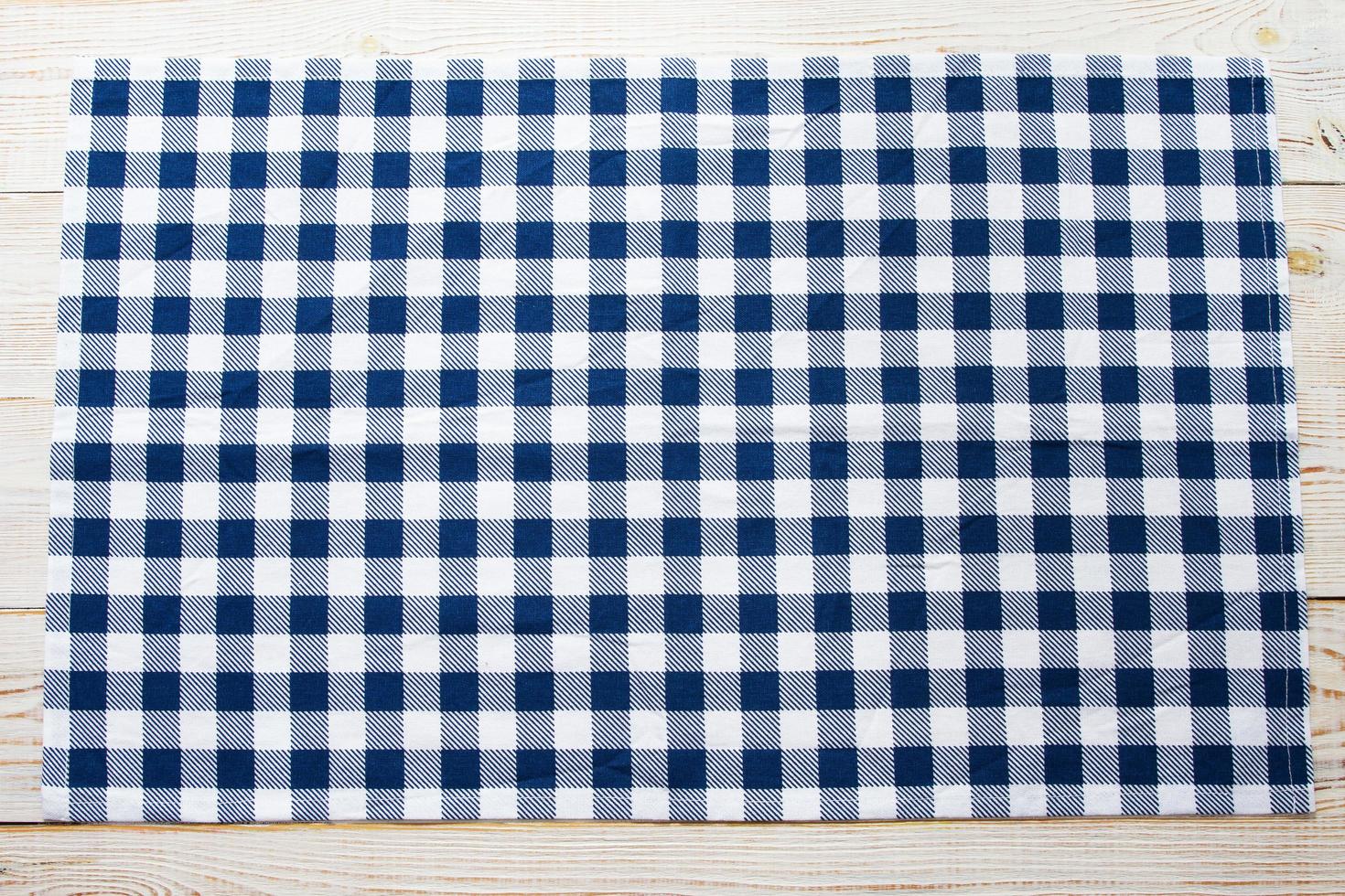 Blue checkered tablecloth on table top view photo