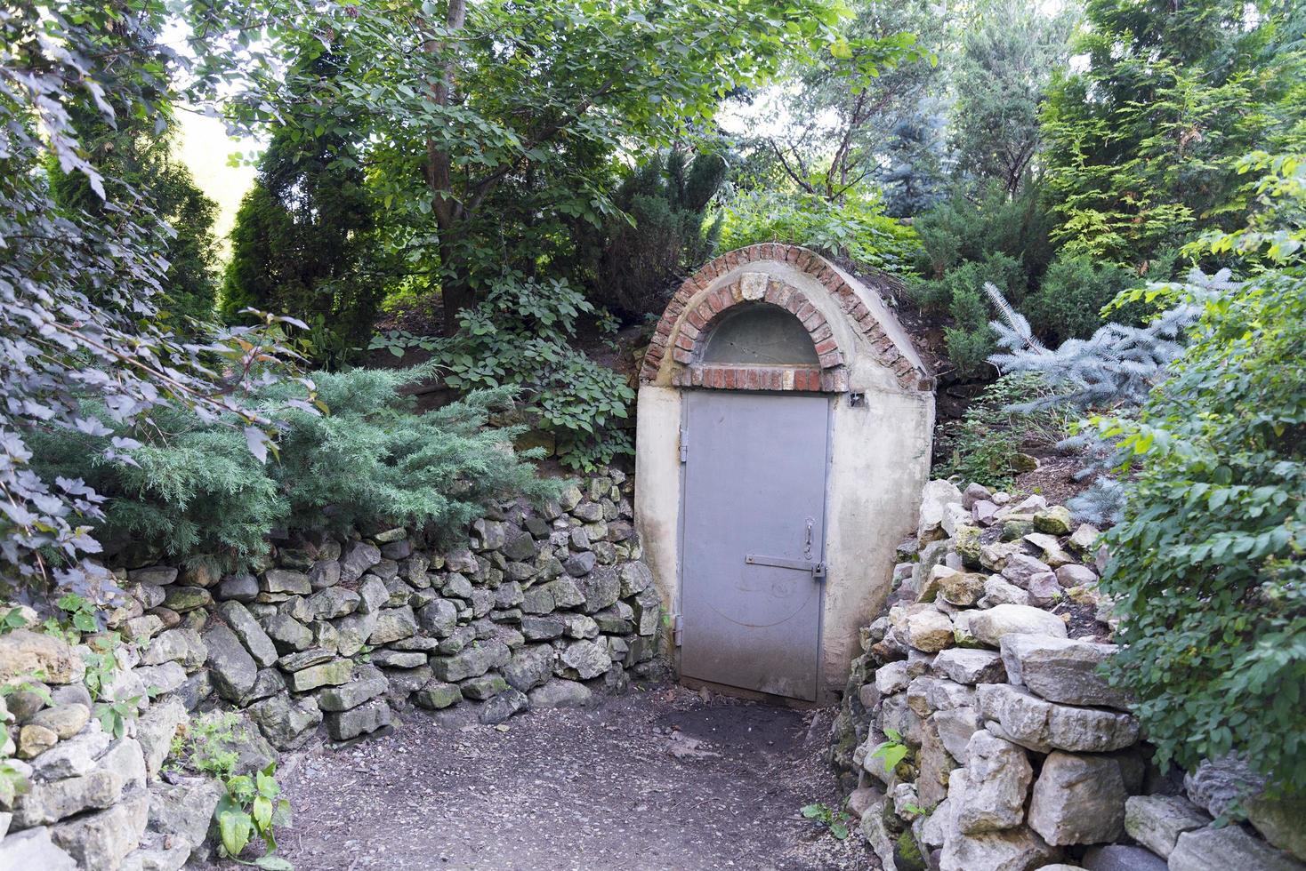 Old bomb shelter in the forest with a forced closed door. photo