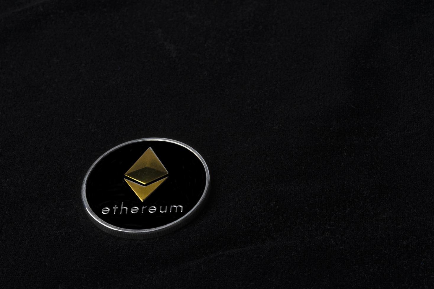 Ethereum coin on black background photo