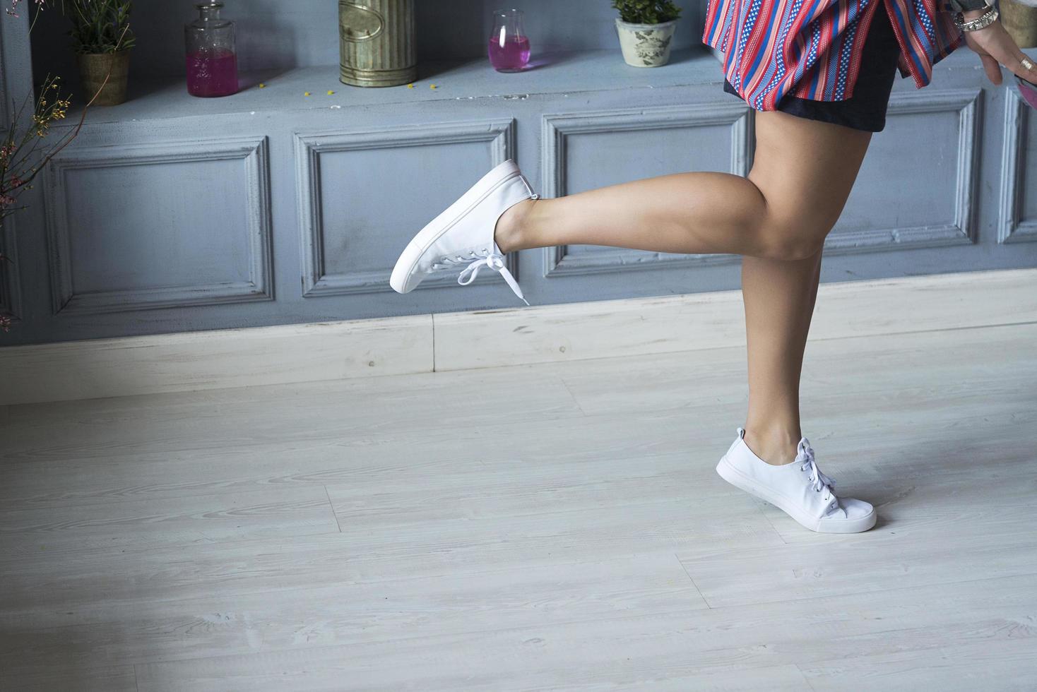 a woman showing off her legs with one foot up in the air. photo