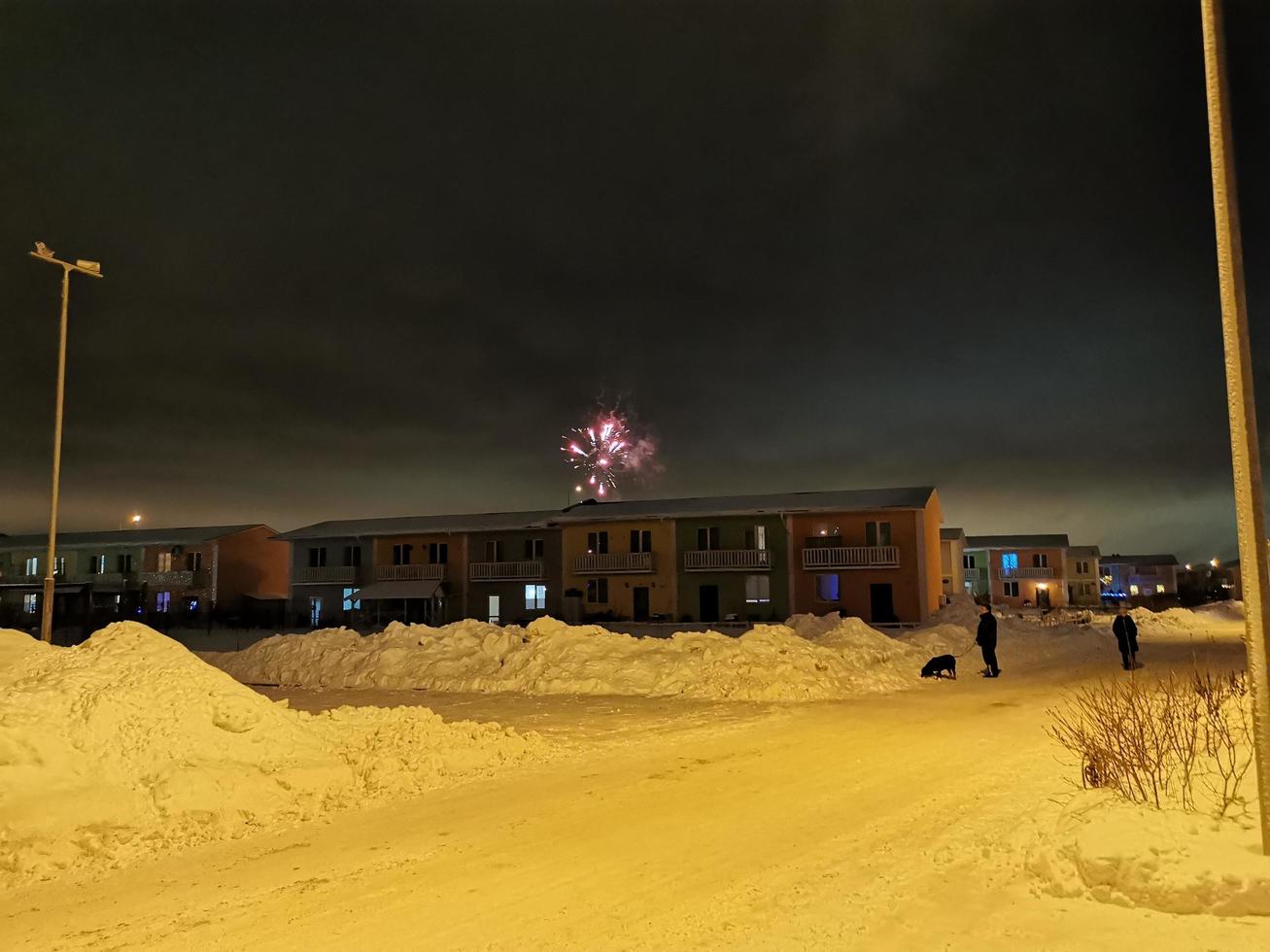 fuegos artificiales de año nuevo en el pueblo de cabañas en una noche de invierno foto