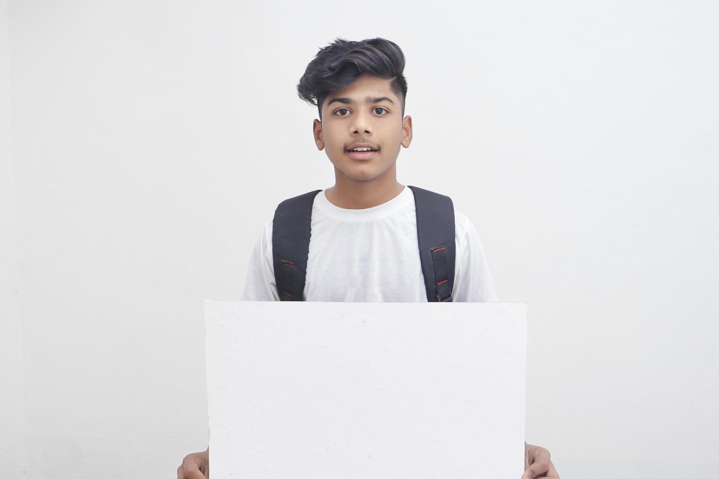 estudiante universitario indio mostrando tablero sobre fondo blanco. foto