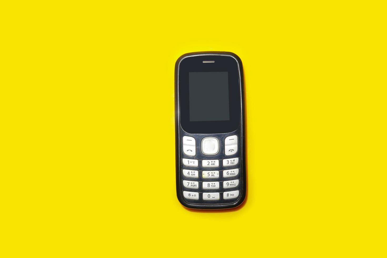 vintage mobile phone with copyspace on yellow background. photo