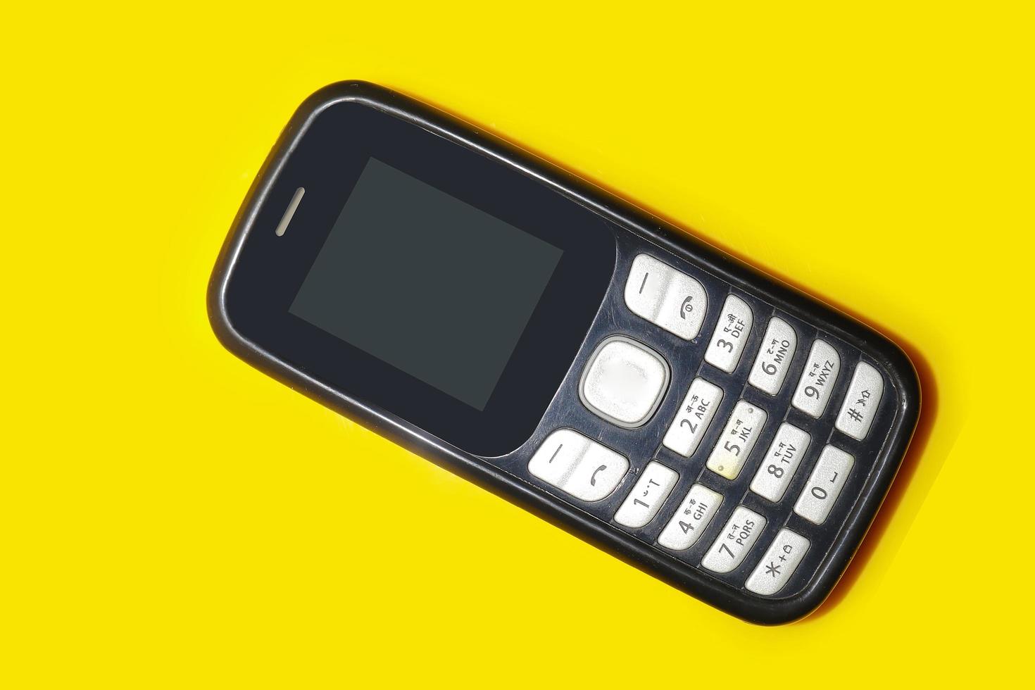 vintage mobile phone with copyspace on yellow background. photo