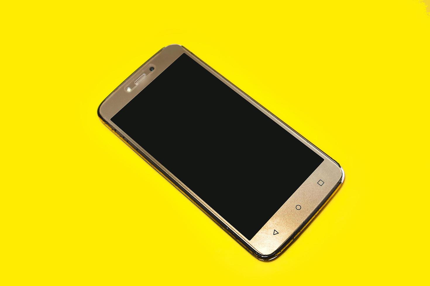 Smart phone on yellow background. photo
