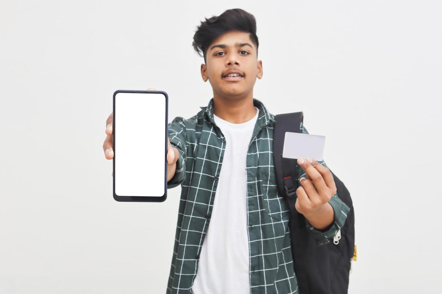 Indian college student showing mobile screen and card on white background. photo