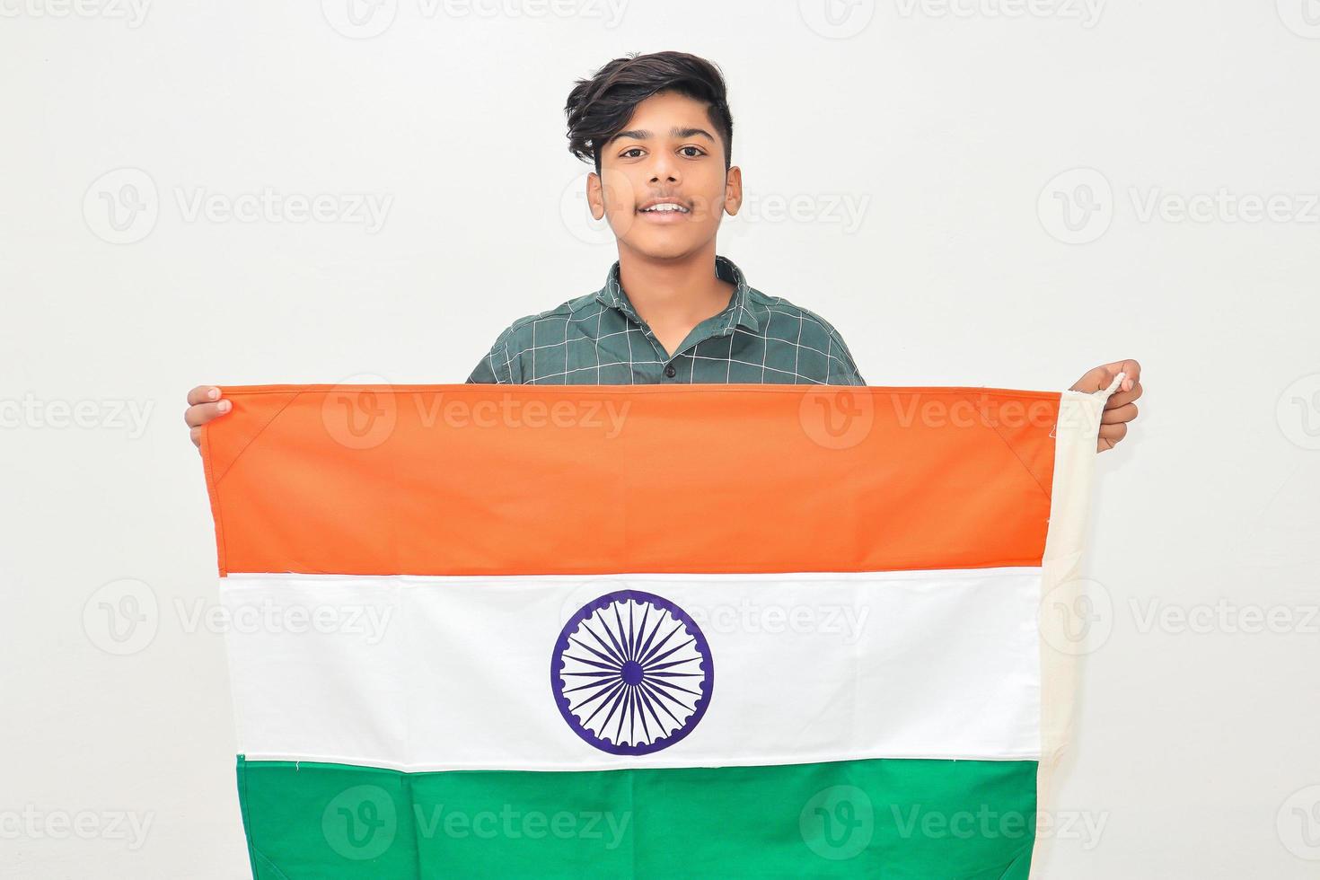 Young indian man holding indian national flag in hand over white background photo