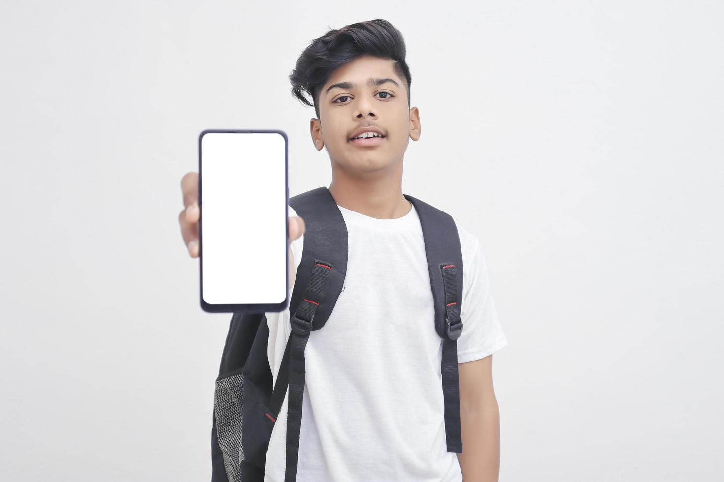 Indian college student showing mobile screen on white background. photo