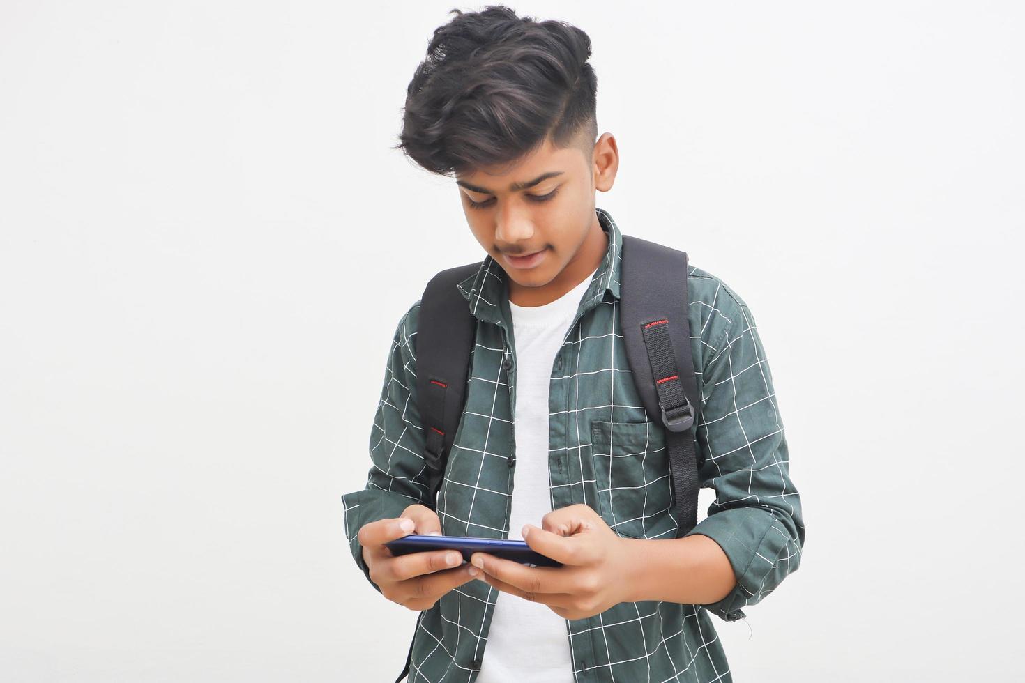 Indian college student using smartphone on white background. photo