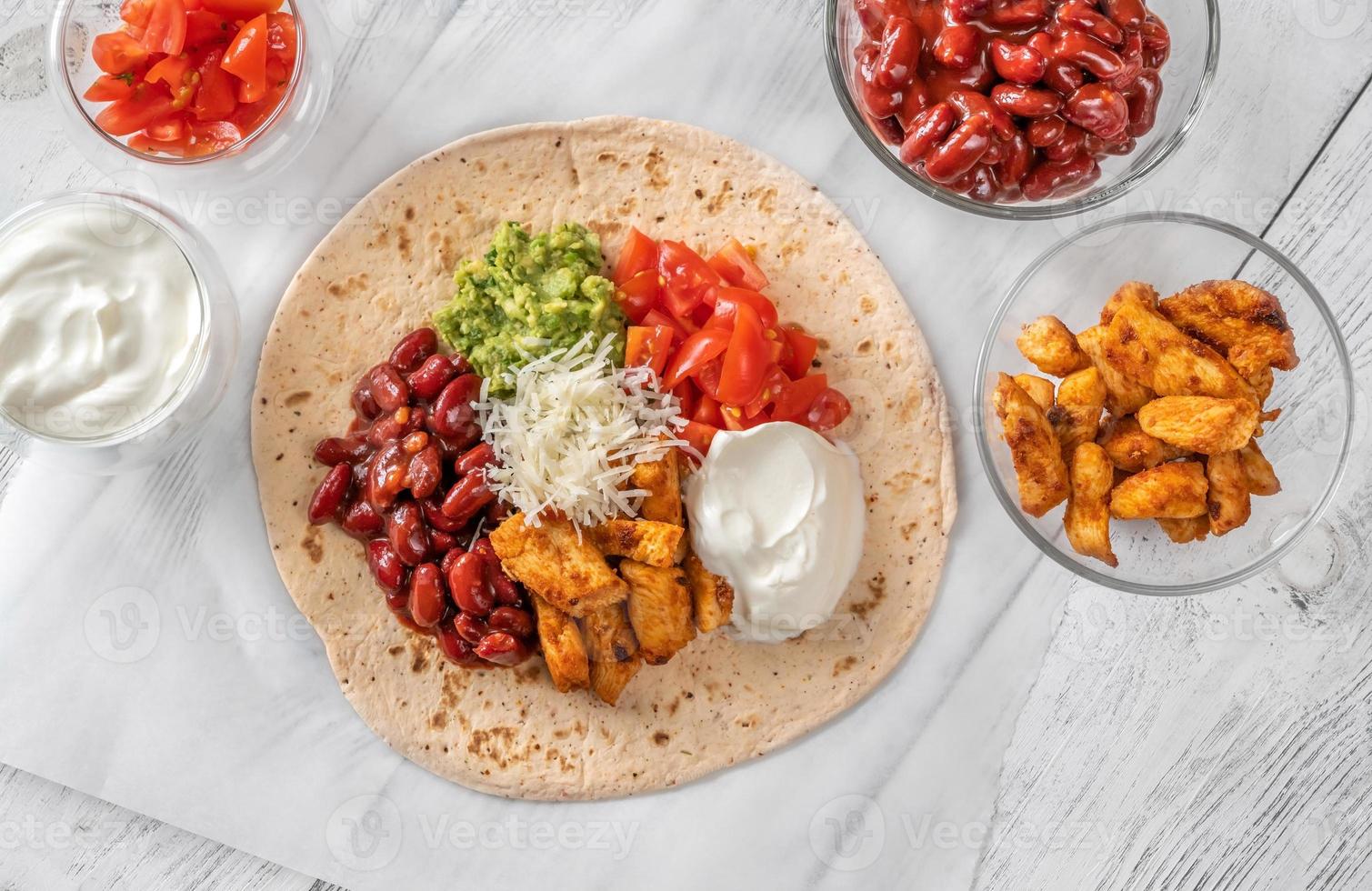 Taco with filling on the wooden background photo