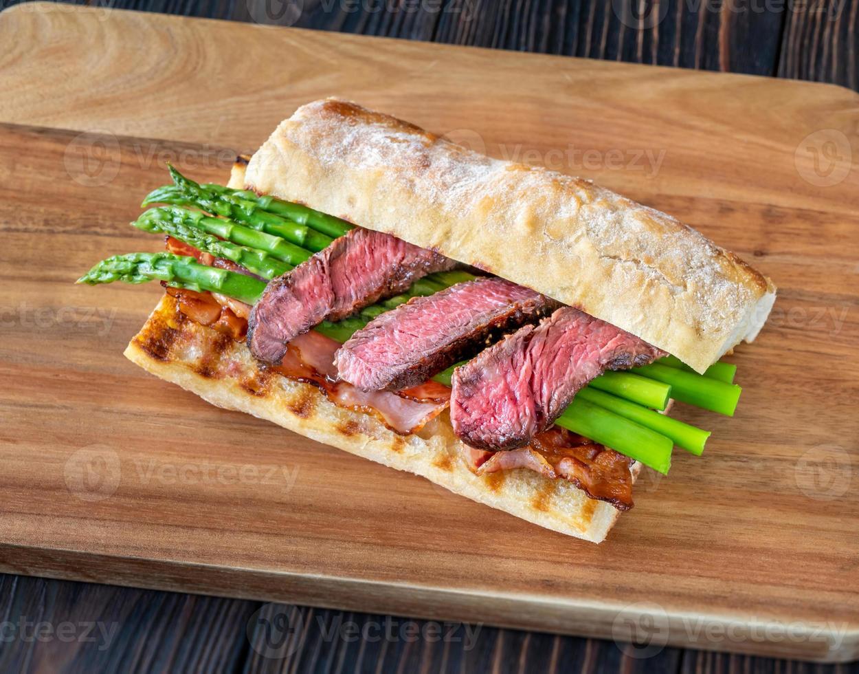 Sandwich with asparagus and slices of beef steak photo