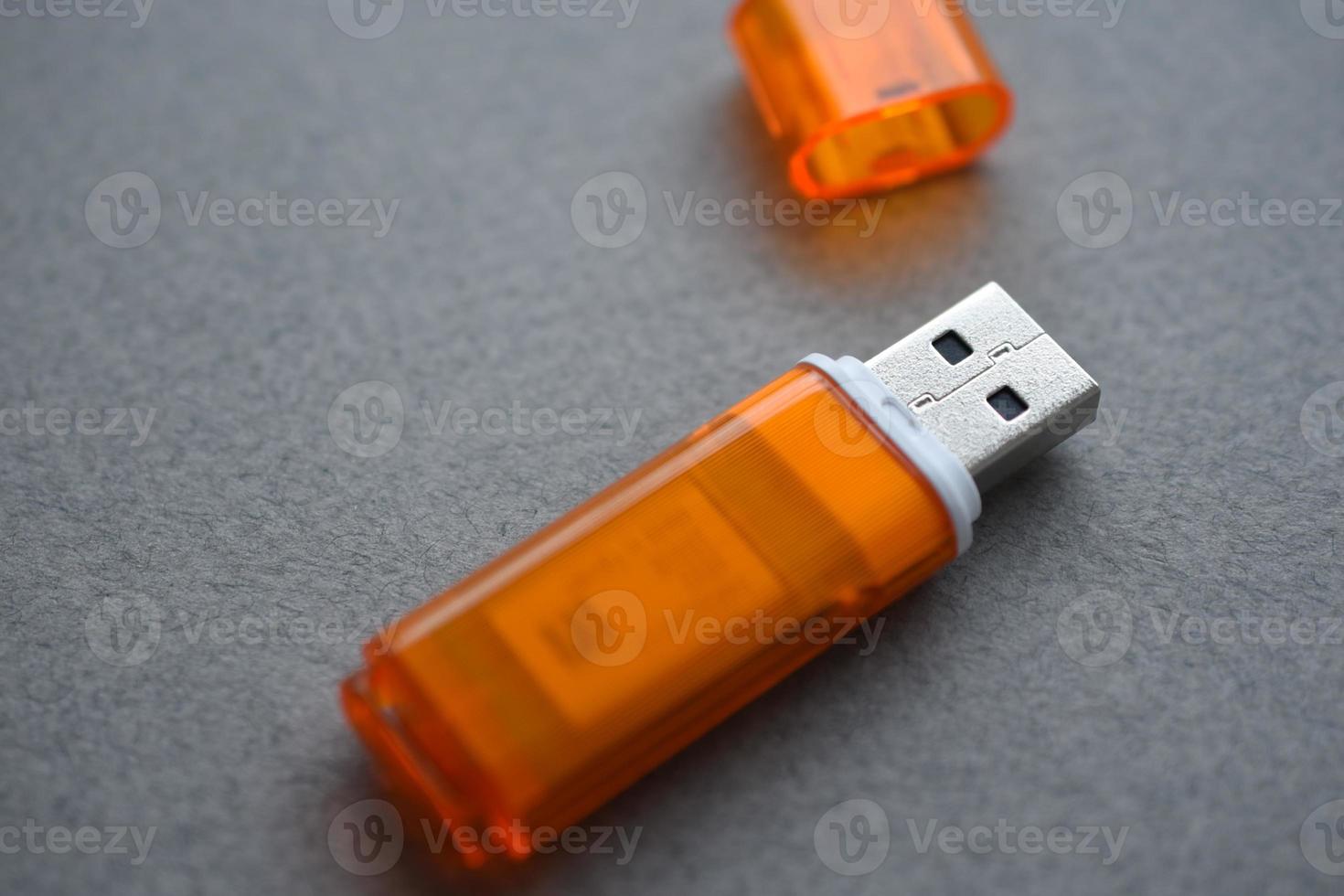 tarjeta flash usb naranja sobre fondo gris foto