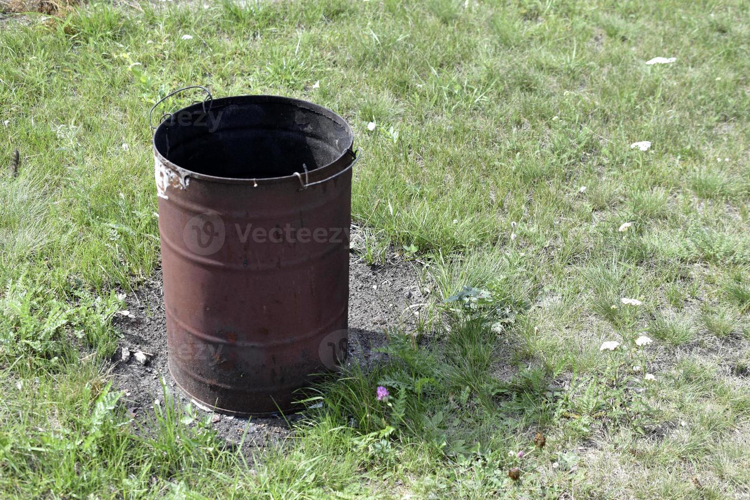 bote de basura quemado en la hierba en verano foto