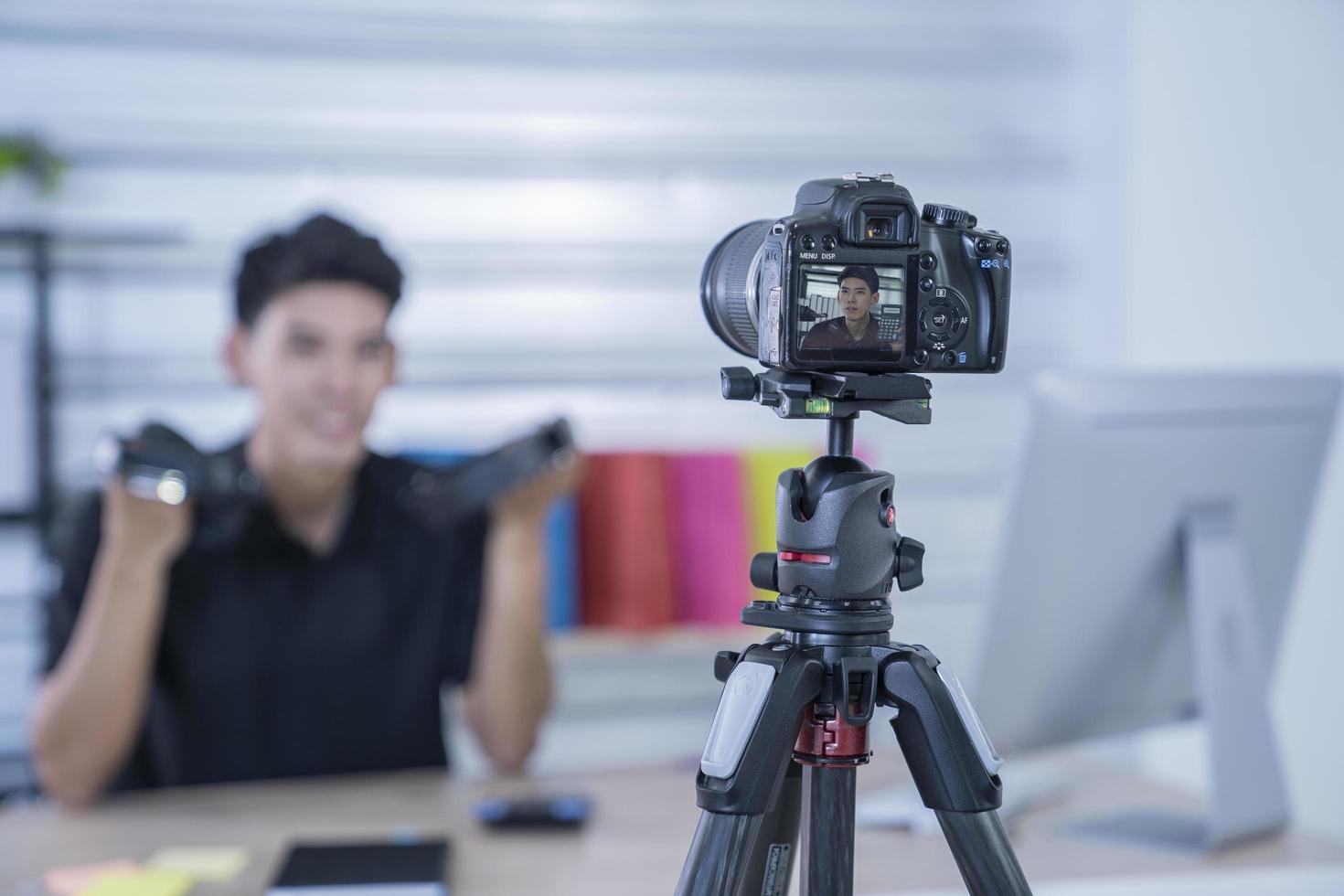 asian man blogger present and review product video broadcast live stream video to a social network. blogging, vlogging, online shopping, and social media concept photo