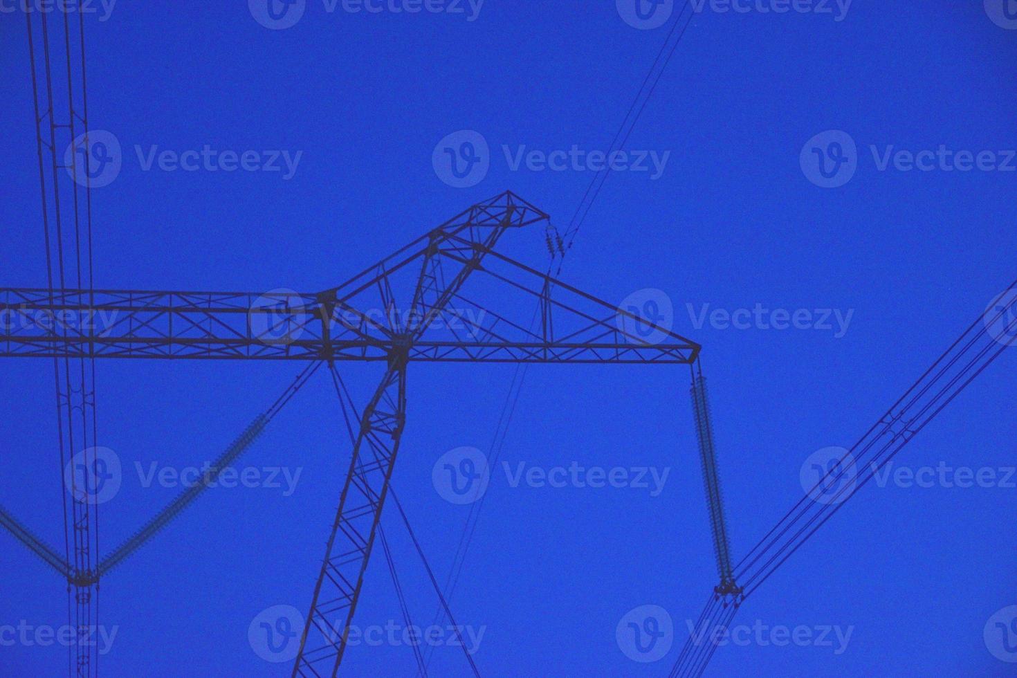 High voltage power line in the evening in the forest photo