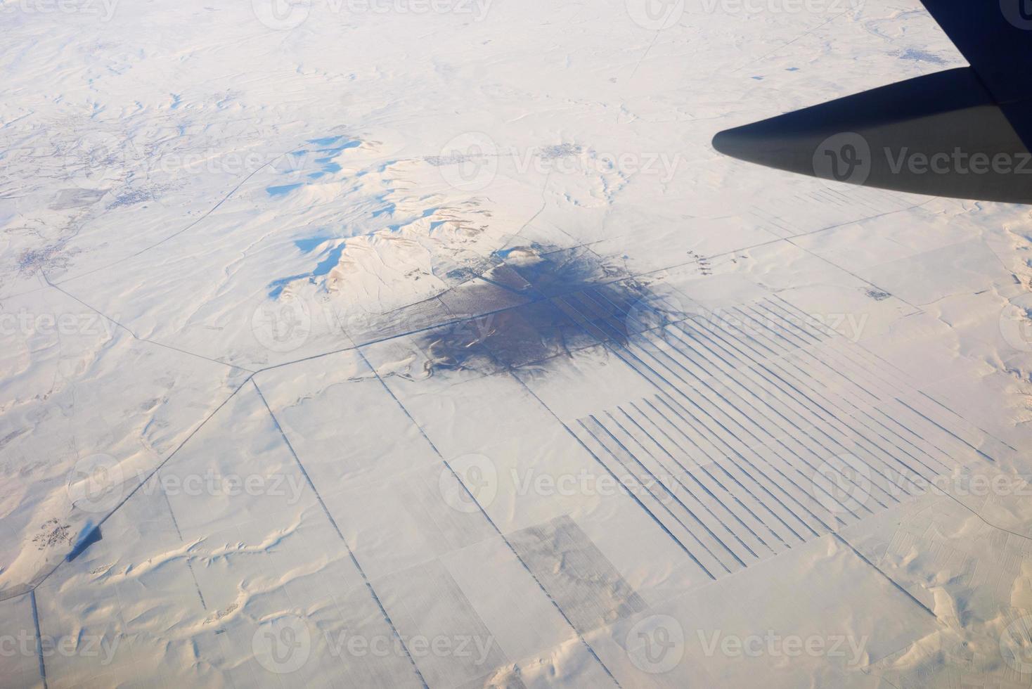 vista al ala de avión en el cielo y montañas nevadas. concepto de viaje y transporte foto