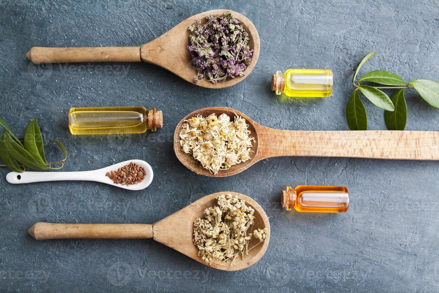 Dry herbs and essences in vintage glass bottles on the table. Alternative medicine. Flat lay photo