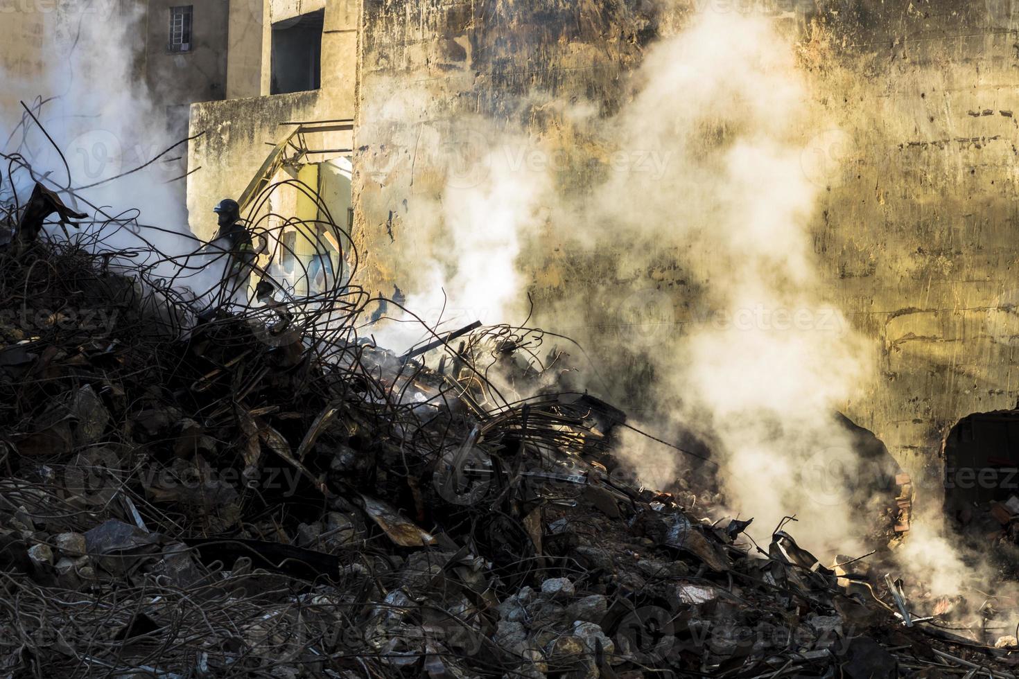 Brazilian firefighter fights flames in the rubble where a 24-story building collapsed after a fire photo
