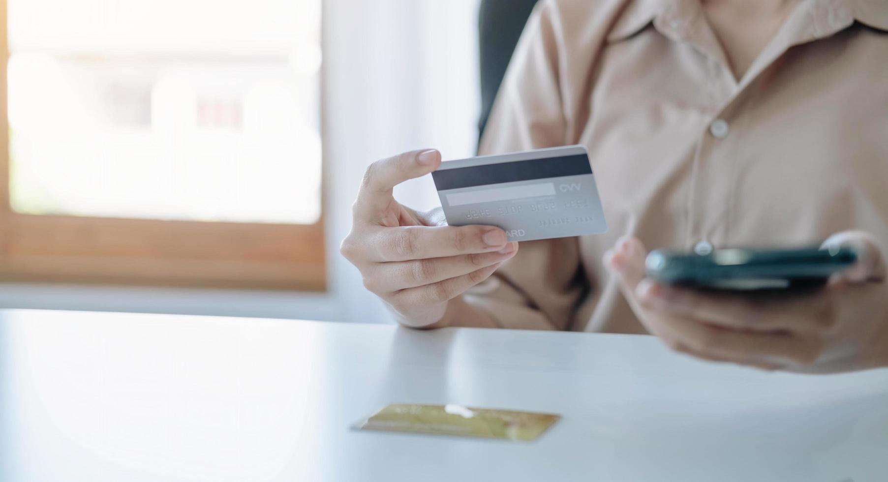 pago en línea, manos de mujer sosteniendo un teléfono inteligente y usando tarjeta de crédito para compras en línea. concepto de lunes cibernético foto