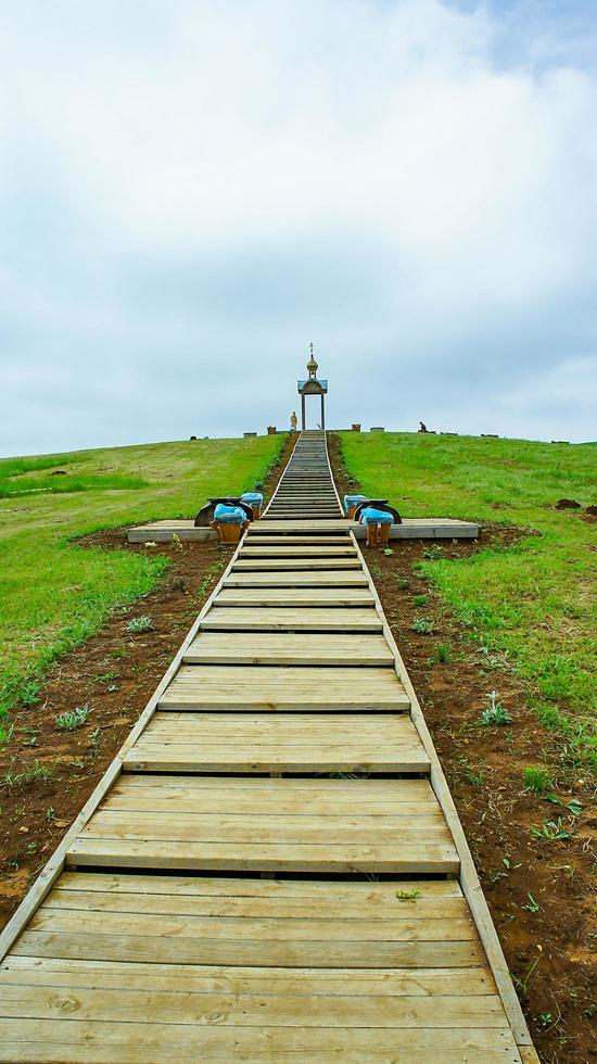 Landscape with wooden staircase and chapel. photo