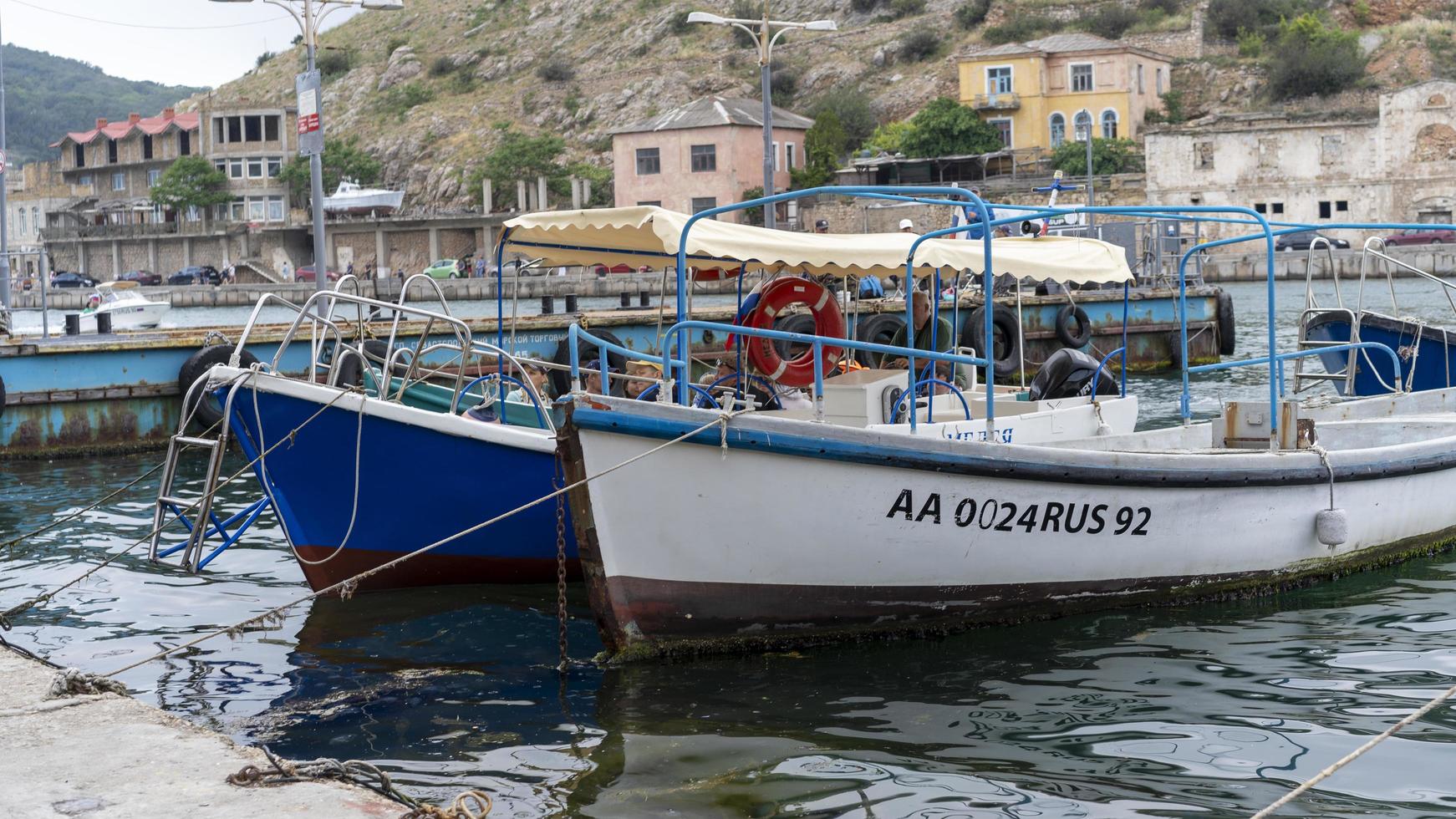 Balaklava, Crimea-June 14, 2021-Seascape overlooking the pier and a boat with tourists. photo