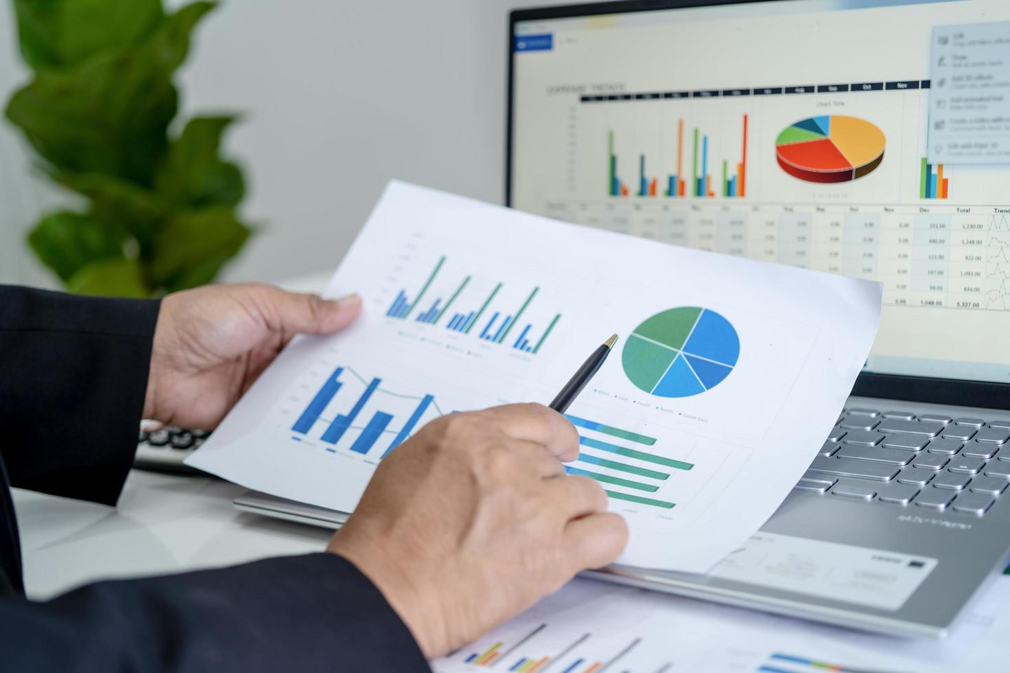 Asian accountant working and analyzing financial reports project accounting with chart graph in modern office, finance and business concept. photo